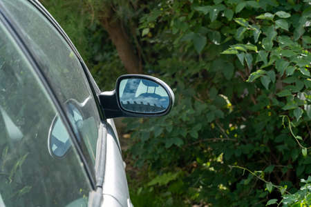 Parked car front door side view mirror seen from behind, detail, closeup, nobody, no people, copy...