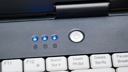 Laptop power button up close, powering on, turning on an electronic device, computer startup concept, closeup, symbol detail. Appliance turning on, led lights coming on indicators blinking, nobodyの写真素材
