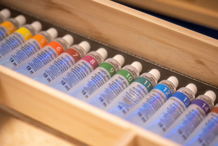 New colorful acrylic paint tubes organized neatly in a simple wooden container. Arts and crafts supplies and art equipment, object closeup, detail, nobody, no peopleのeditorial素材