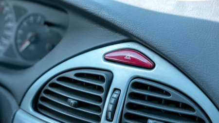 Car interior main dashboard detail up close emergency stop red hazard lights button in the middle, nobody. Vehicle inside detail shot, object closeup no people, emergencies accidents abstract conceptの写真素材