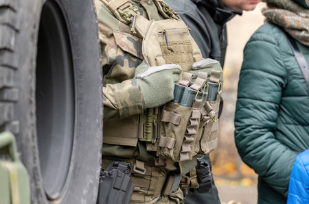 Fully equipped soldier with a generic tactical vest holding many spare magazines, ammunition, detail closeup. Anonymous professional infantry soldier fighter with full equipment on the street, warfareの写真素材