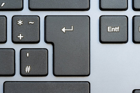 Close-up shot of an Enter key on a modern computer keyboard, completing an action, sending a chat...