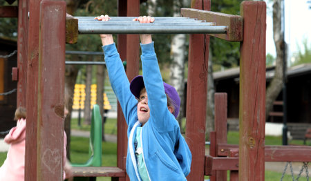 School age children two girls playing around on the playground, climbing, kids and fun physical...