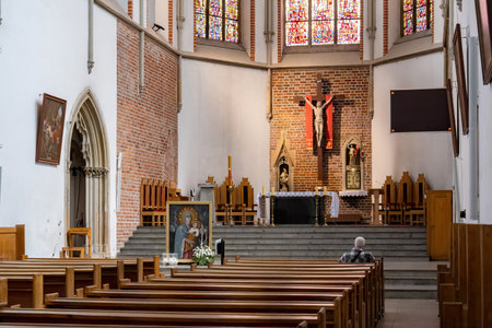 A lone man kneels in prayer at the St Adalberts Church, Wroclaw, Poland facing the altar with...