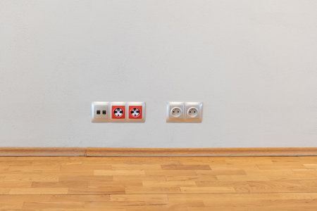 Multiple power sockets on a white gray wall modern contemporary interior design low angle shot,...