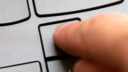 Man pressing the up arrow key on a modern laptop computer keyboard, closeup detail, one person....