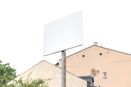 Blank white rectangular sign outdoors with trees and houses in the background, empty signage for advertising or information, mockup template for real estate or traffic purposesの写真素材