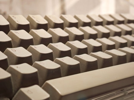 Close-up of a simple vintage beige tone computer keyboard, retro style PC keys with shallow depth of field, classic technology concept, macro detail of old computing hardware, beige nostalgic designの写真素材