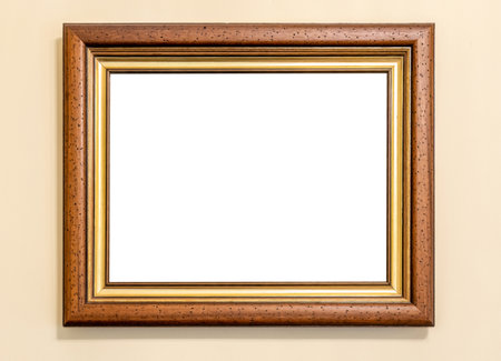 Horizontal wooden picture frame with gold trim hanging on a cream wall, blank white cut out inside...