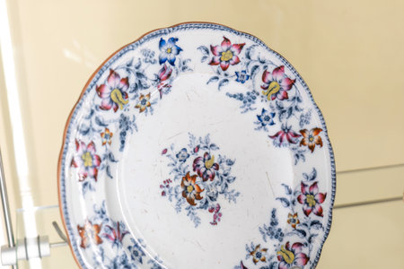 Antique porcelain plate with colorful floral decorative ornate patterns on display, single object, vintage ceramic tableware dish, elegant decorative cultural heritage collection closeup, no peopleの写真素材