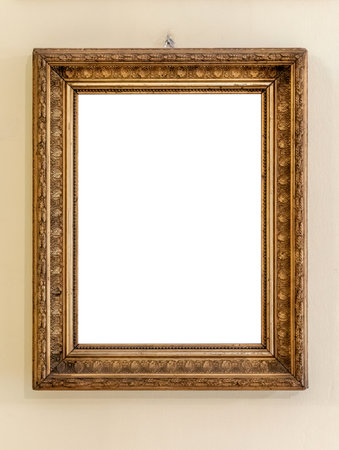Ornate antique gold picture frame hanging on wall with blank empty cut out white interior for...