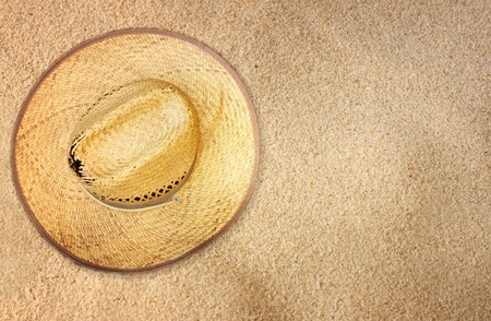 top view of straw hat on beach sandの写真素材