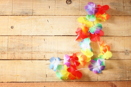 Necklace of bright colorful flowers lei on wooden backgroundの写真素材