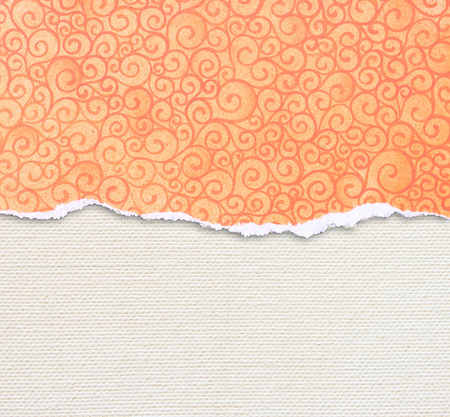 orange torn paper edge with pattern over canvas backgroundの写真素材