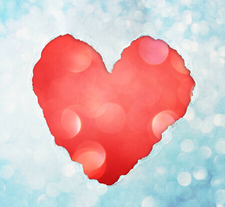 red heart shape made from torn paper over glitter boke soft lights の写真素材