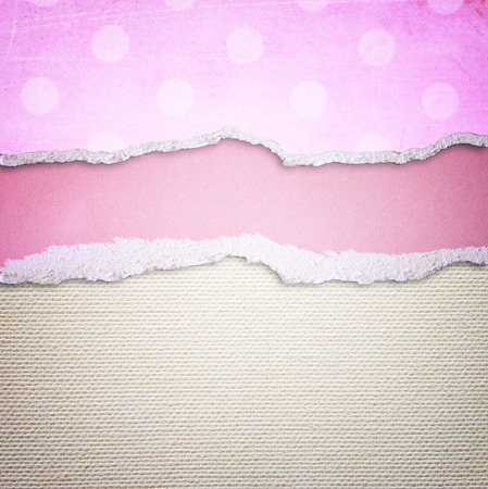 pink torn paper over textured canvas backgroundの写真素材