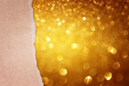 torn paper over golden glitter bokeh lightsの写真素材