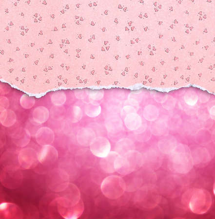 pink torn paper with hearts pattern over pink bokeh backgroundの写真素材