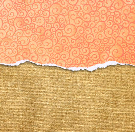 orange torn paper edge with pattern over canvas backgroundの写真素材