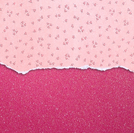 pink torn paper with hearts pattern over pink glitter backgroundの写真素材