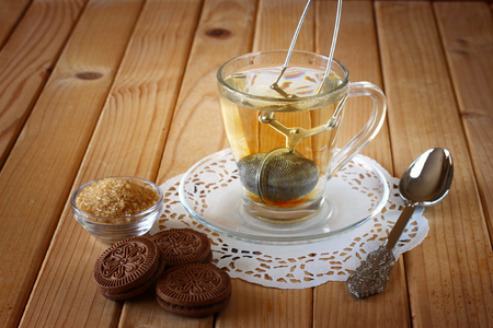 fresh chocolate cookies and hot black tea over wooden tableの写真素材