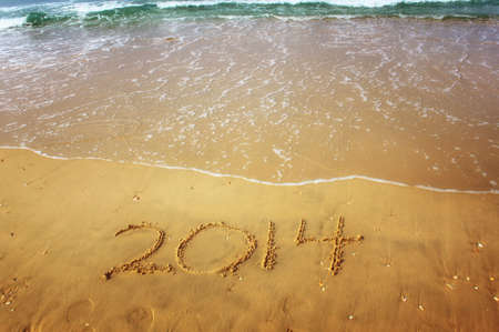 New Year 2014 is coming concept written on beach sandの写真素材