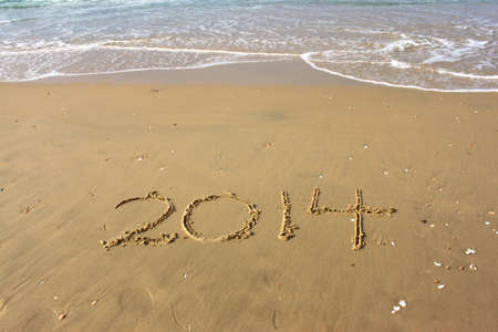 New Year 2014 is coming concept written on beach sandの写真素材