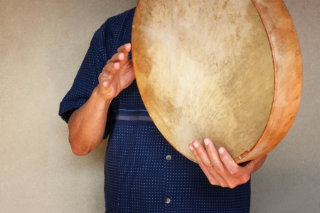senior musician playing ethnic drum 