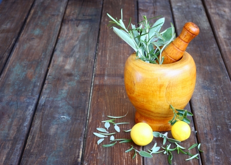 fresh rosemary herbs in wooden pestle and mortar on wooden tableの写真素材