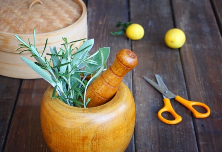 fresh rosemary and sage herbs in wooden pestle and mortar  natural light の写真素材