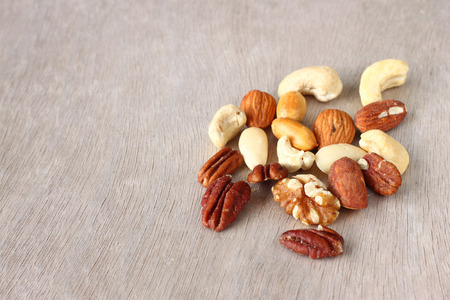 Assorted healthy mixed nuts on wooden textured background  の写真素材