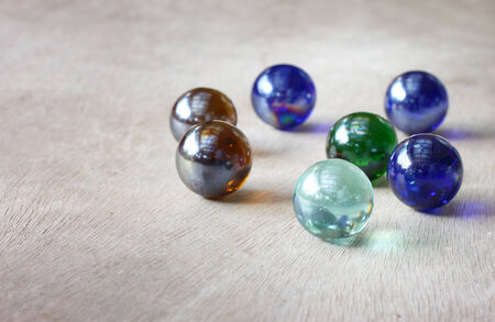 top view of collection of shiny marbles on wooden background  の写真素材