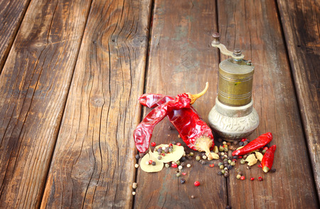 metal spice grinder with red hot peppers and bay leaf  の写真素材
