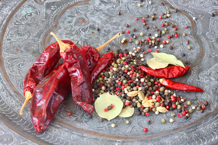 metal spice grinder with red hot peppers and bay leaf  の写真素材