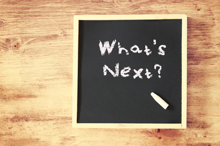 whats next concept written on blackboard over wooden background  の写真素材