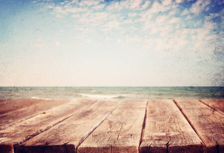 wood planks in front of sea landscape  lens flare  filtered image  の写真素材
