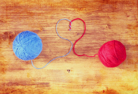 Two wool balls with heart shape over wooden board  の写真素材