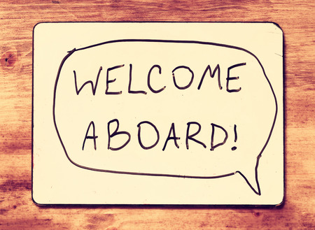 drawing board with the phrase welcome aboard handwritten over wooden board  filtered image   の写真素材