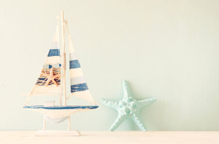 decorative boat and seashell over wooden textured background  の写真素材
