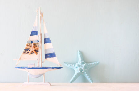 decorative boat and seashell over wooden textured background  の写真素材