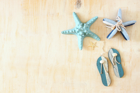 star fish and wooden flip flops decoration over white textured wooden background の写真素材