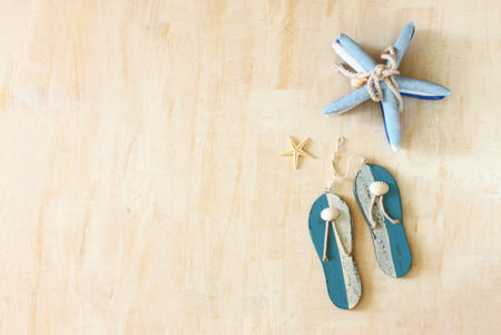 star fish and wooden flip flops decoration over white textured wooden background の写真素材