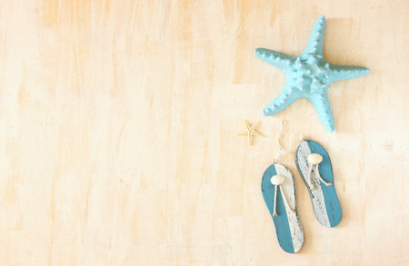 star fish and wooden flip flops decoration over white textured wooden background の写真素材