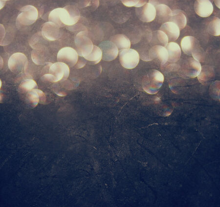 abstract bokeh lights over blackboard textured background  の写真素材