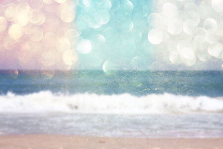 background of blurred beach and sea waves with bokeh lights, vintage filter   の写真素材