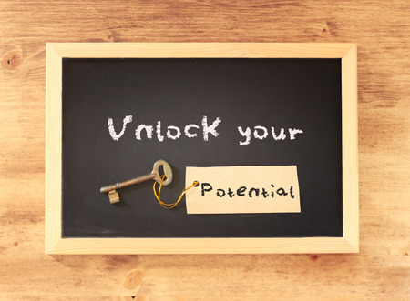 top view of blackboard with the phrase unlock your potential written on it   の写真素材