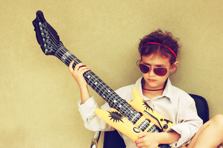 Happy kid playing with toy guitarの写真素材
