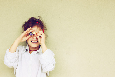 Happy kid playing with binocularsの写真素材