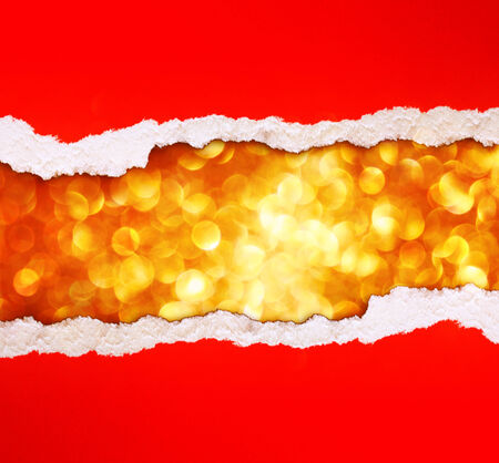 red torn paper over glitter golden lights background.の写真素材