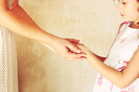 mother and child holding hands over pink textured backgroundの写真素材